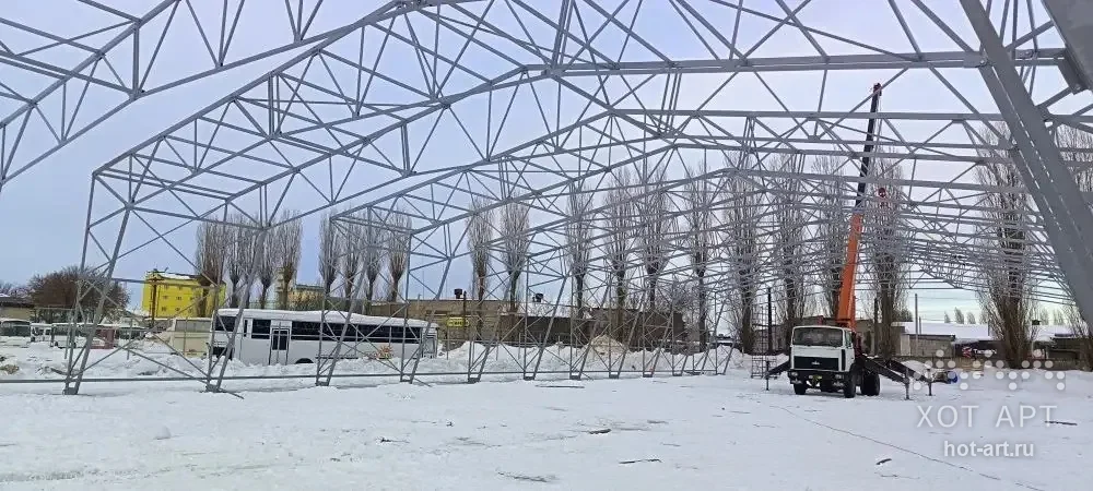 Каркас ангара на зимней площадке: смонтированные рамы со связями и автокран у торца